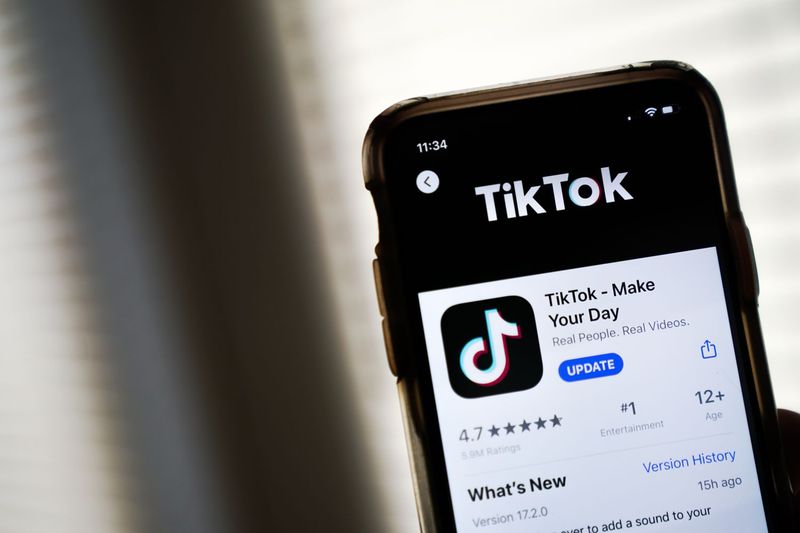TikTok logo displayed on a smartphone with U.S. flag colors in the background.